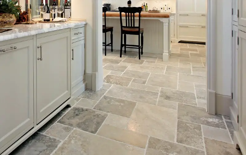 Kitchen featuring light-colored stone flooring and modern cabinets