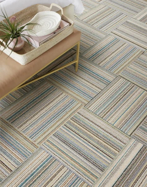 A stylish room featuring a modern striped carpet and a small table with a plant.